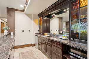 Bathroom featuring vanity, recessed lighting, ornamental molding, and light tile patterned floors