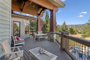 Wooden deck featuring outdoor dining space and a mountain view