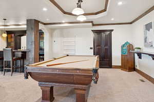 Playroom featuring recessed lighting, a raised ceiling, ornamental molding, light colored carpet, and arched walkways