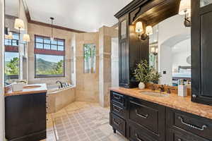 Bathroom with two vanities, a bath, a mountain view, and light tile patterned floors