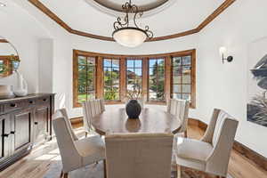 Dining room with light wood-style floors and crown molding