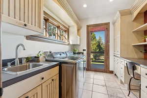 Laundry area featuring cabinet space, recessed lighting, washer and clothes dryer, and light tile patterned floors