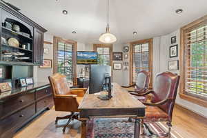 Office area with light wood-style floors and recessed lighting