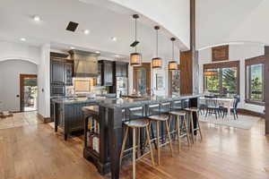 Kitchen featuring arched walkways, hanging light fixtures, a kitchen bar, healthy amount of natural light, and recessed lighting