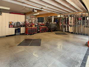 Garage with a workshop area, a heating unit, and a garage door opener