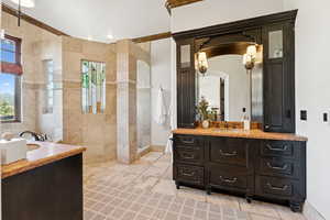 Full bathroom with two vanities, walk in shower, and tile walls