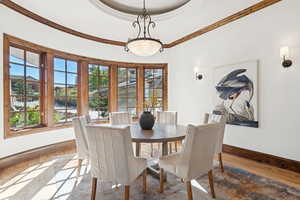 Dining area featuring wood finished floors, healthy amount of natural light, and crown molding