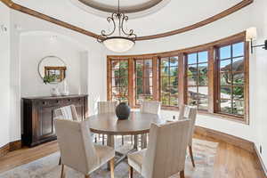 Dining area with wood finished floors and crown molding