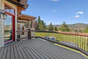 Deck featuring a mountain view and a lawn