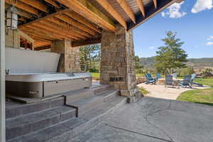 View of patio / terrace with a mountain view and a hot tub