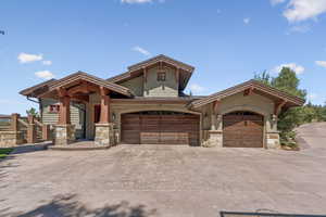Craftsman house with stone siding, concrete driveway, and an attached garage