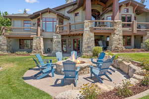 Back of house featuring a patio, a fire pit, a yard, a balcony, and french doors