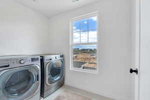 Laundry area with light tile patterned floors and washer and dryer