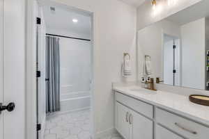 Bathroom featuring light tile patterned flooring, vanity, and shower / tub combo