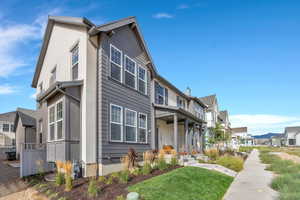 Rear view of house with a residential view, covered porch, and a yard