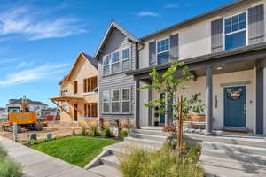 View of front of home featuring a porch, a front lawn, and stucco siding