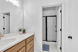 Full bath featuring a stall shower, vanity, and light tile patterned flooring