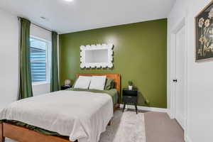 Carpeted bedroom featuring baseboards