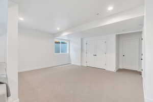 Below grade area featuring light colored carpet and recessed lighting