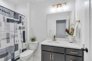 Bathroom featuring a shower with shower curtain, vanity, and light tile patterned flooring