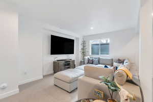 Carpeted living area featuring baseboards and recessed lighting