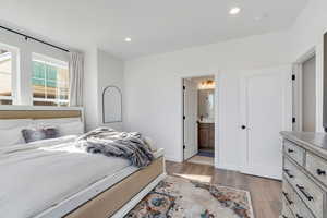 Bedroom featuring recessed lighting, light wood finished floors, and ensuite bath