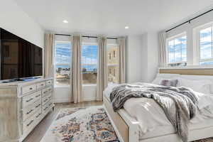 Bedroom with multiple windows, light wood finished floors, and recessed lighting