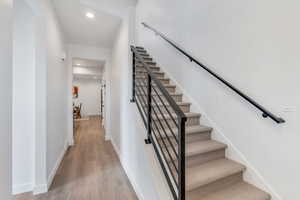 Staircase featuring recessed lighting and wood finished floors