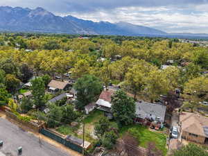 Aerial view of residential area featuring a mountain backdrop and a forest