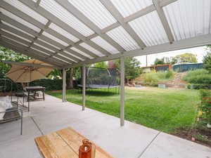 View of patio featuring a trampoline and stairway
