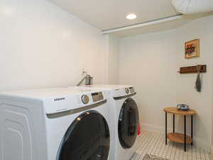Laundry room with light tile patterned floors, independent washer and dryer, and recessed lighting