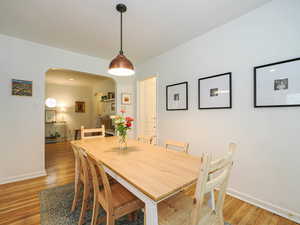 Dining room featuring arched walkways and light wood finished floors