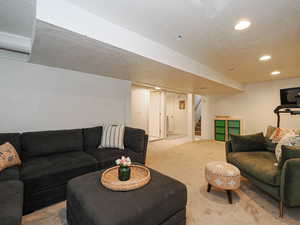 Carpeted living room featuring stairway and recessed lighting