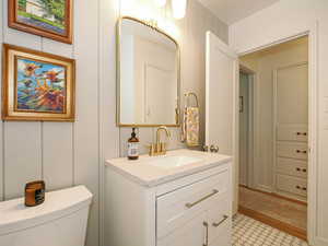 Half bath featuring vanity and a decorative wall