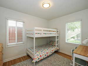 Bedroom with baseboards and dark wood-type flooring