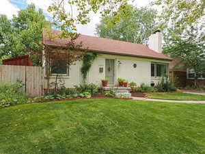 View of front of home featuring a tile roof, brick siding, and a chimney