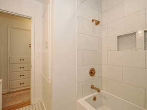Bathroom with bathtub / shower combination and baseboards
