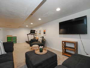 Living area featuring light colored carpet and recessed lighting