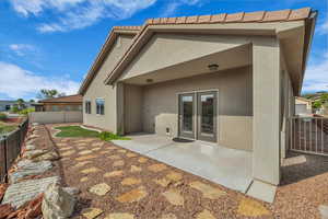 Back of house featuring a fenced backyard, stucco siding, and a patio area