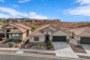 Mediterranean / spanish-style house with stone siding, concrete driveway, an attached garage, stucco siding, and a residential view
