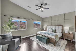 Bedroom featuring high vaulted ceiling, wood finished floors, a decorative wall, and a ceiling fan