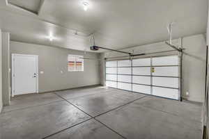 Garage featuring baseboards and a garage door opener