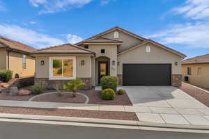 Mediterranean / spanish house with stone siding, an attached garage, driveway, and stucco siding
