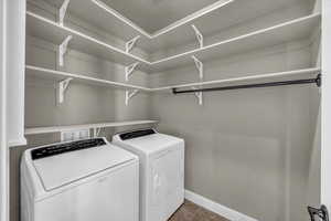 Washroom featuring washer and dryer and dark tile patterned flooring