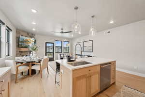Kitchen with light brown cabinets, open floor plan, a ceiling fan, light wood-style floors, and dishwasher