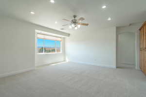 Spare room featuring recessed lighting, arched walkways, light carpet, ceiling fan, and a mountain view