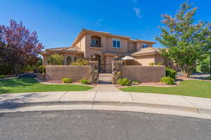 Mediterranean / spanish-style home with a gate, a fenced front yard, a tiled roof, and stucco siding