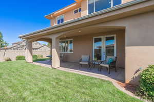 Back of property with stucco siding and french doors