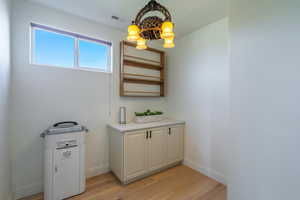 Detailed view of wood finished floors and a chandelier