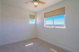 Spare room with carpet floors, a mountain view, and a ceiling fan